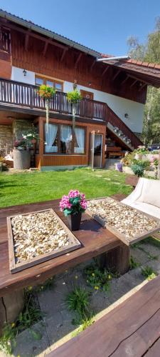 a patio with two trays of leaves on a table at Ubytování v šumavském domě in Nové Hutě
