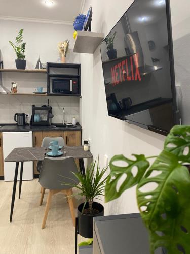a dining room with a table and a kitchen at Contento Apartments in Almaty