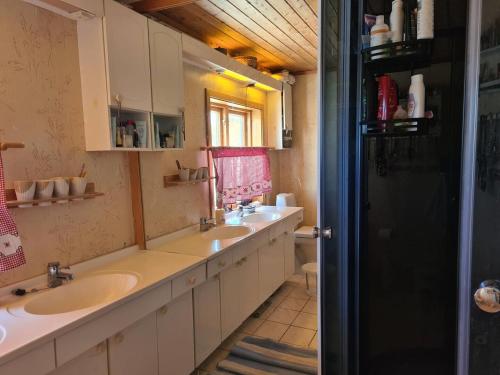 a bathroom with two sinks and a mirror at Peaceful property with spectacular sea view in Leknes
