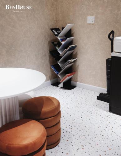 a room with a stool and a table and shelves at BenHouse Homestay in Ho Chi Minh City