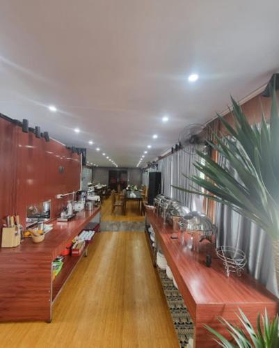 a long room with long wooden tables and plants at New Sun Hotel Sapa in Sa Pa