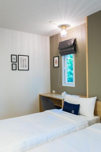 a bedroom with two beds and a window at Zayn Express & Suites in Bangkok