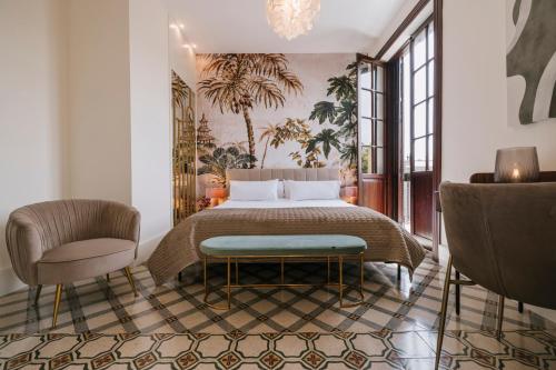a bedroom with a bed and a chair at MASANET Emblematic Hotels - Adults Only in Las Palmas de Gran Canaria
