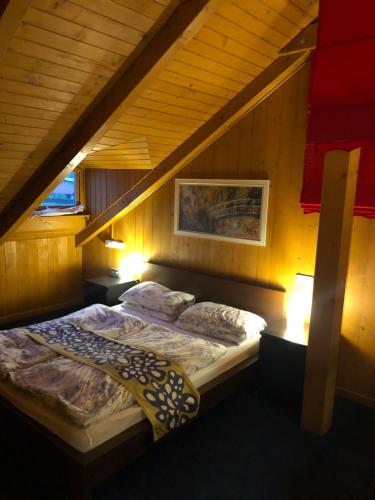 a bed in a room with an attic at Happy Village Kastiel Ivachnova in Ivachnová