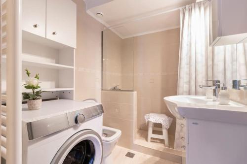une salle de bain blanche avec une machine à laver et un lavabo dans l'établissement Vintage Charm Apt near Centre, à Héraklion
