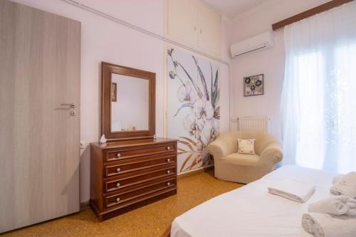 - une chambre avec une commode avec un miroir et une chaise dans l'établissement Vintage Charm Apt near Centre, à Héraklion