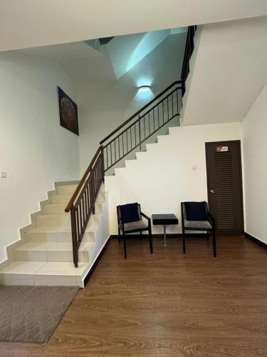 two chairs sitting next to a staircase in a building at MP Villa with Cinema Room in Hock Lam Village