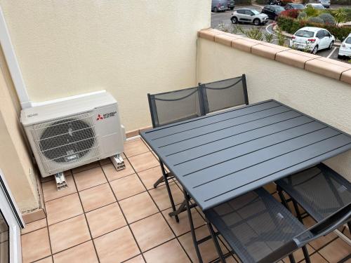 d'une table et de chaises sur un balcon avec chauffage. dans l'établissement Appartement cap d'agde, au Cap d'Agde