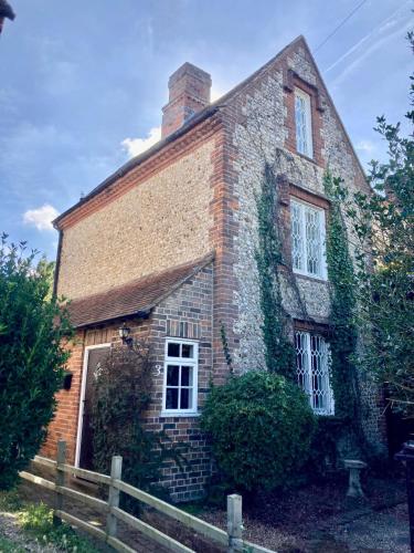an old brick house with ivy on it at Picturesque Cottage in Oving- cosy pub & beaches in Oving