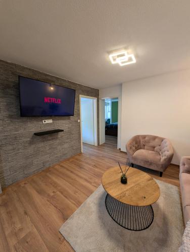 a living room with a table and a tv on a wall at Privatunterkunft in Göppingen in Göppingen