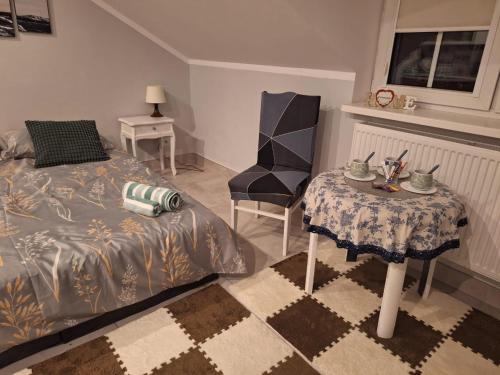 a bedroom with a bed and a table and a chair at Niyaz apartment in Warsaw
