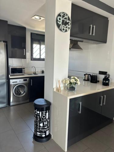 a kitchen with black and white cabinets and a counter at OasisBeach Penthousse la Zénia in Playas de Orihuela