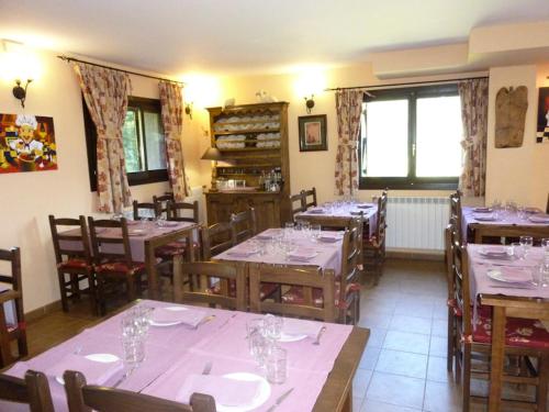a dining room with tables and chairs with glasses at Hostal Parque Natural in Benasque