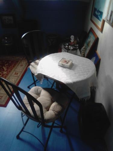 une table avec deux chaises et une table avec un tissu de table blanc dans l'établissement Happy days, à Spézet