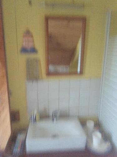 une salle de bain avec un lavabo blanc et un miroir dans l'établissement Happy days, à Spézet