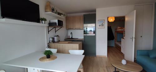 Il comprend une petite cuisine et un salon avec une table blanche. dans l'établissement Studio Arcachon, quartier de l'Aiguillon, à Arcachon