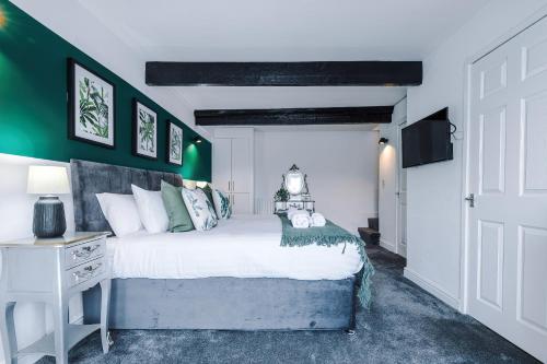 a bedroom with a bed and a green wall at 'Apple Store' - Mochdre Cottages in Mochdre