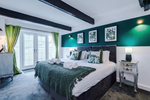 a bedroom with a large bed with green walls at 'Apple Store' - Mochdre Cottages in Mochdre