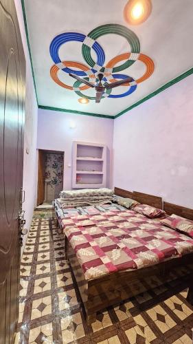 ein Schlafzimmer mit einem Bett und einer Decke mit einem Kronleuchter in der Unterkunft Rana Homestay in Ukhimath
