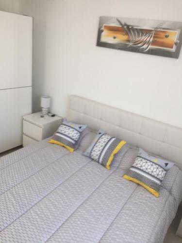 - un lit avec deux oreillers et une photo sur le mur dans l'établissement Ales Cevennes villa confort et tranquillité, à Saint Julien Les Rosiers