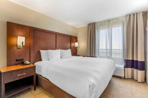 a hotel room with a large bed and a window at Comfort Suites Blythe in Blythe