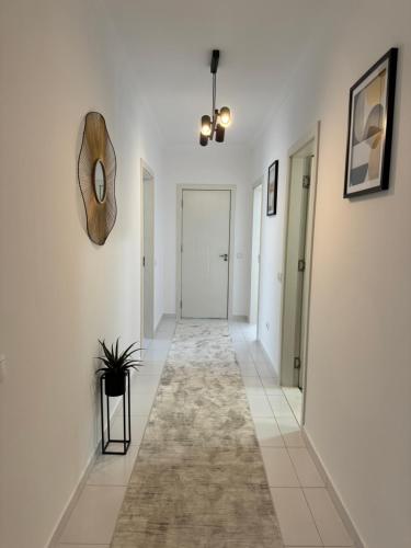 a hallway with white walls and a mirror on the wall at Penthouse Exclusive in Pristina
