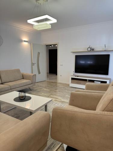 a living room with couches and a flat screen tv at Penthouse Exclusive in Pristina
