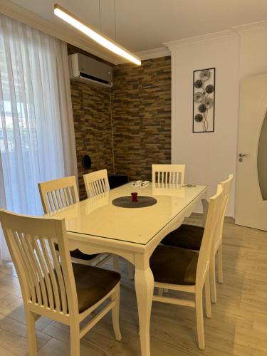 a dining room with a white table and chairs at Penthouse Exclusive in Pristina