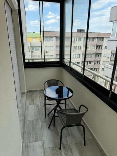 a balcony with a table and chairs and windows at Penthouse Exclusive in Pristina