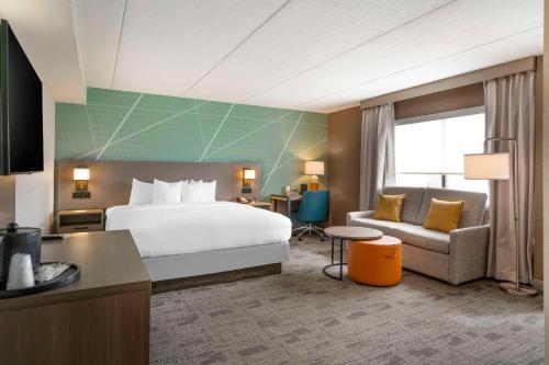 a hotel room with a bed and a couch at Comfort Inn & Suites Watertown - 1000 Islands in Watertown