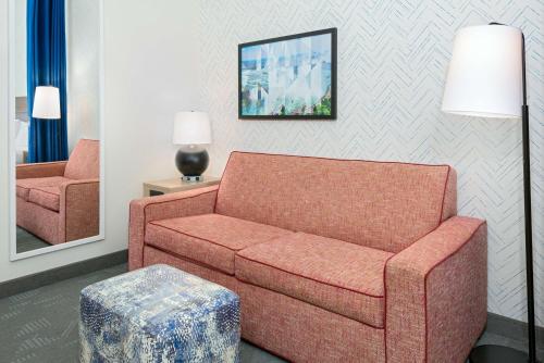 a living room with a couch and a chair at Home2 Suites by Hilton Buffalo Airport/ Galleria Mall in Cheektowaga