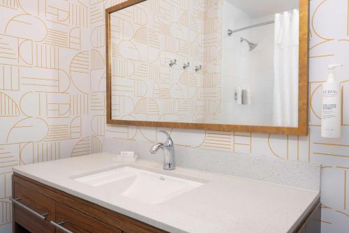 a bathroom with a sink and a mirror at Home2 Suites by Hilton Buffalo Airport/ Galleria Mall in Cheektowaga