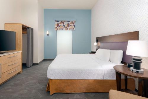 a hotel room with a bed and a television at Home2 Suites by Hilton Buffalo Airport/ Galleria Mall in Cheektowaga