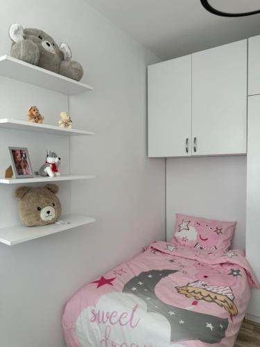 a childs bedroom with a pink bed and shelves at Penthouse Exclusive in Pristina