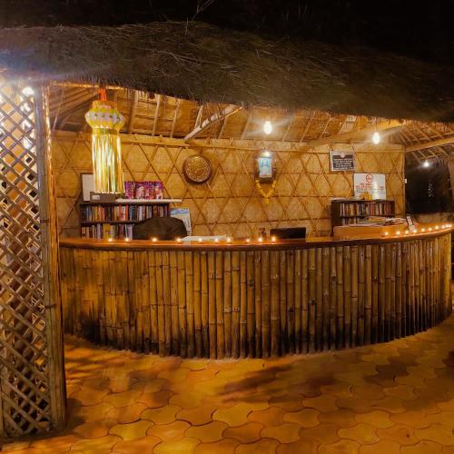 a bar with a wooden counter in a room at Dunes Holiday Village in Mandrem