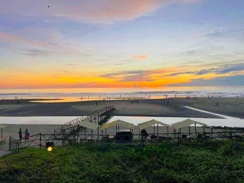 a sunset at the beach with tents on the beach at Dunes Holiday Village in Mandrem