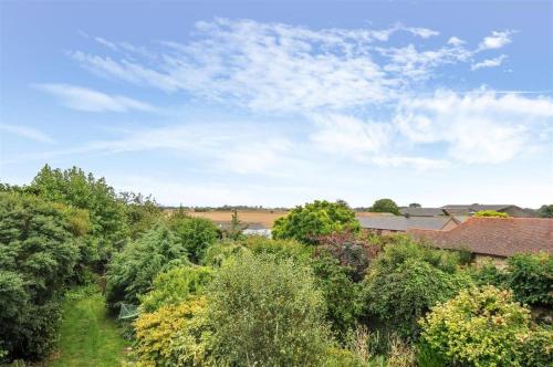 a view from the roof of a house with trees at Picturesque Cottage in Oving- cosy pub & beaches in Oving