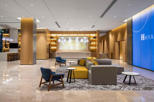a lobby with a couch and chairs and tables at Hyatt Place New Taipei City Xinzhuang in Xinzhuang