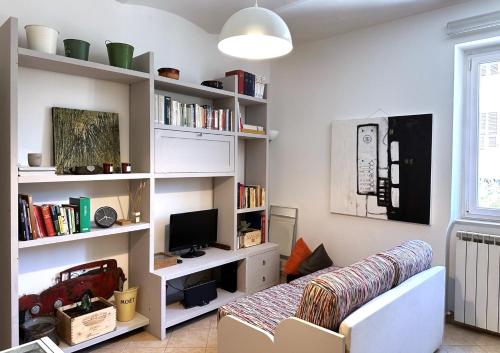 a living room with a couch and book shelves at Centralissimo - Nuovo - Parcheggio Privato in Perugia