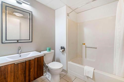 a bathroom with a toilet and a sink and a shower at Black Bear Inn, an Ascend Collection Hotel in Orono