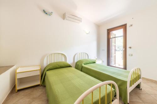 ポルト・ピノにあるCasa Martiniの窓のある部屋にベッドが2つある