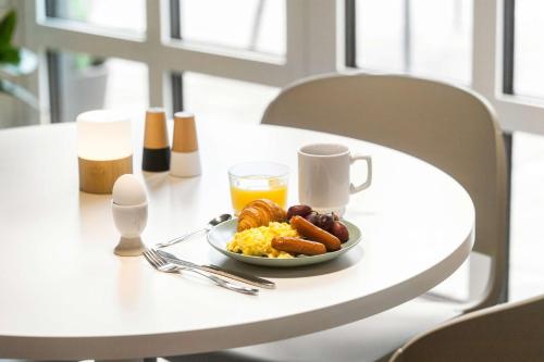 a table with a plate of breakfast food and a glass of orange juice at Aiden by Best Western Lolland in Holeby