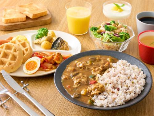 a table with a plate of food with rice and waffles at Comfort Inn Kurashiki Mizushima in Kurashiki