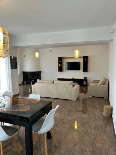 a living room with a black table and white chairs at Villa Ellania Milos in Adamantas