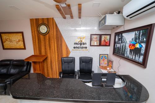 a conference room with a table and chairs and a clock at Magan Enclave in Kuttālam