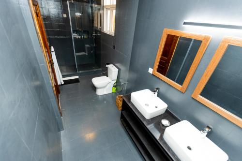 a bathroom with two sinks and two toilets at Amata n'Ubuki Boutique Hotel Ltd in Kigali