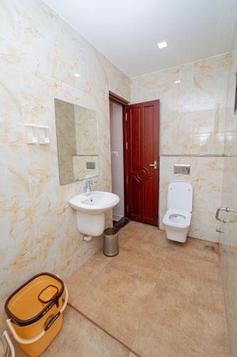 a bathroom with a sink and a toilet in it at Magan Enclave in Kuttālam