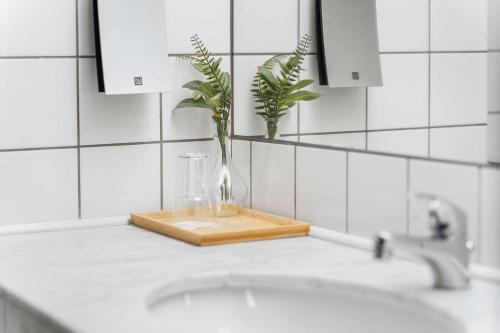 a bathroom sink with a vase with a plant in it at Best Western Plus Hotel Odense in Odense
