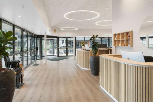 an office lobby with a reception desk and windows at Best Western Plus Hotel Odense in Odense