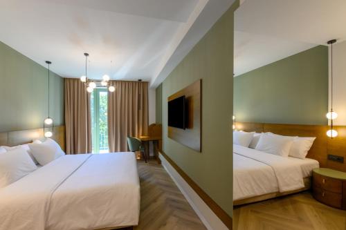 a hotel room with two beds and a tv at Luna Residence Villa in Timişoara